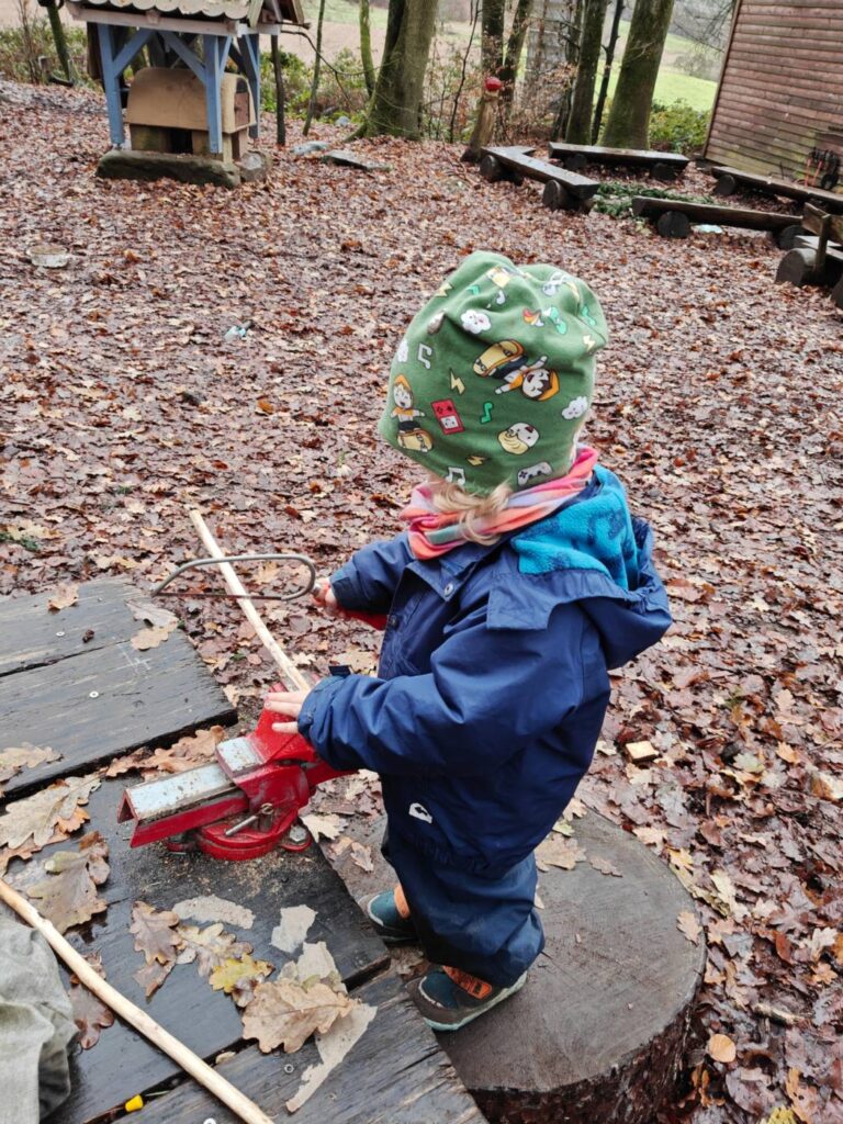 Kind in Winterkleidung und Mütze am Waldplatz