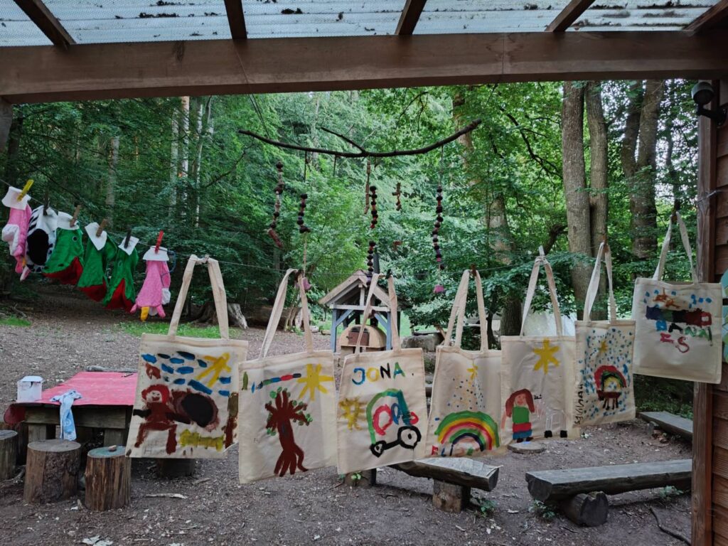 Vordach der Schutzhütte am Waldplatz mit selbst bemalten Taschen
